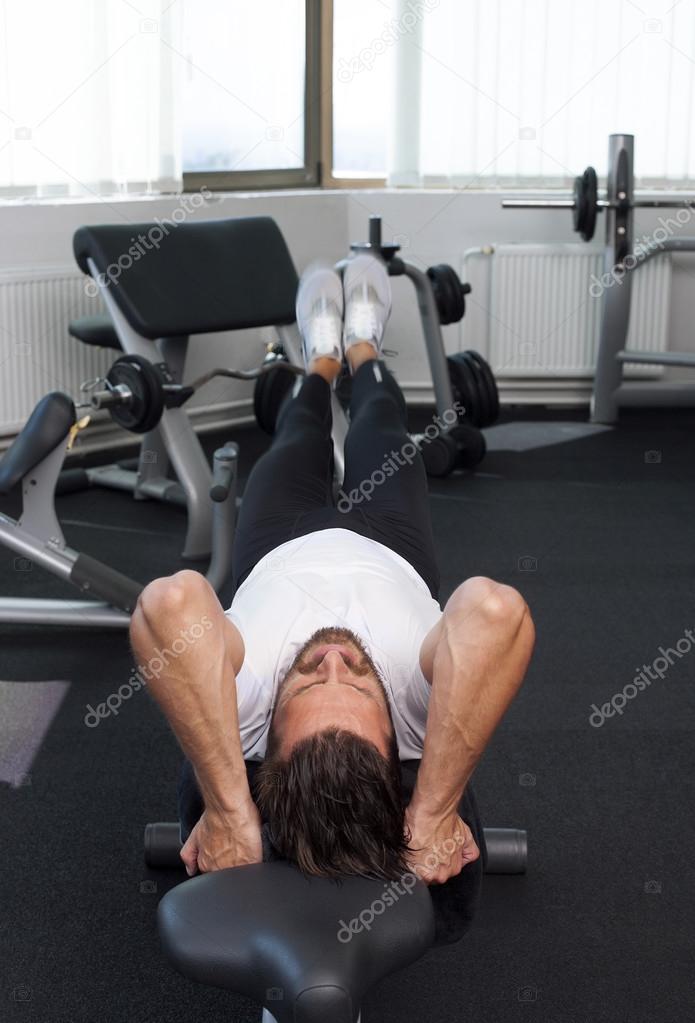 Leg Raise On Bench Man Raising Legs In Gym Fitnes Stock Photo
