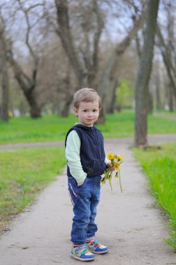 Karahindiba çiçek tutan küçük bir çocuk