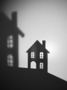 Tepedeki küçük evlerin soyut siyah beyaz silueti. Yumuşak ışık ve bulanık gölgelerle minimalist bir sahne. Evi, hafızayı ve sakin şehir hayatını simgeliyor..