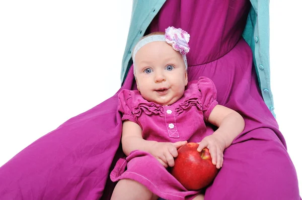 Baby mit Apfel in den Händen der Mutter — Stockfoto