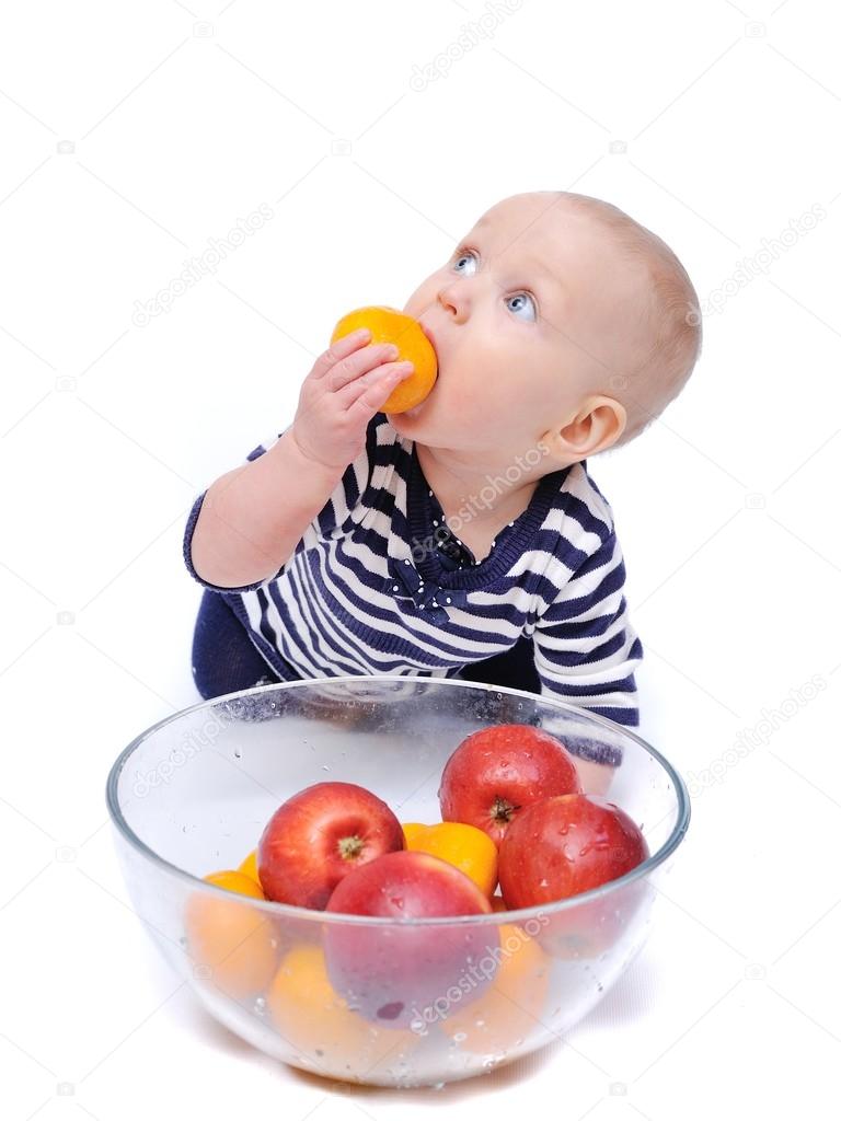 Baby with fruits in a clear bowl