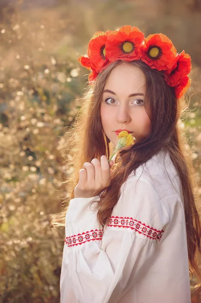 Дівчина в українському національному костюмі рідного з квіткою — стокове фото