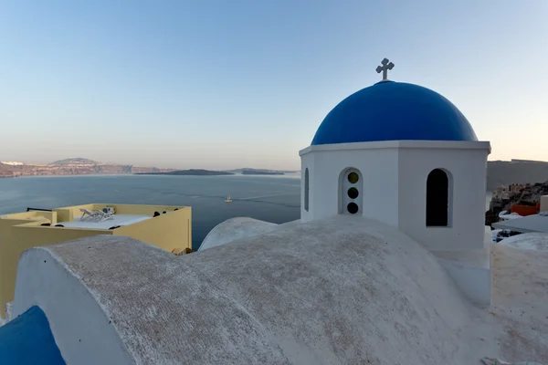 Kyrkan med blått tak i staden Oia och panorama till Santorini island, Grekland — Stockfoto