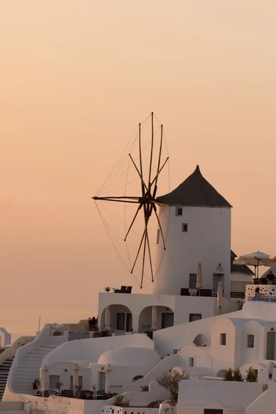 Puesta de sol sobre molinos de viento blancos en la ciudad de Oia y panorama a la isla de Santorini, Grecia — Foto de Stock