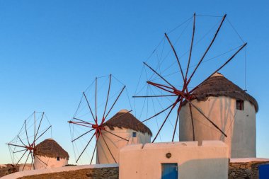 Beyaz üzerinde güneşin son ışınları yel değirmenleri Mykonos, Yunanistan adada