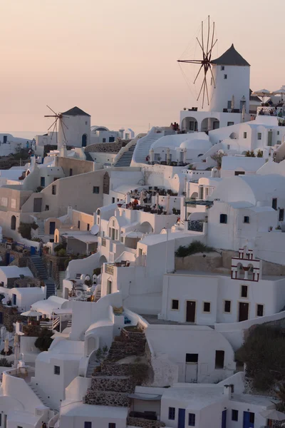 Zonsondergang over witte windmolens in de gemeente van Oia en panorama naar Santorini eiland, Thira, Griekenland — Stockfoto