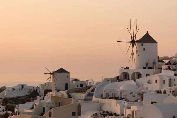 Increíble puesta de sol sobre molinos de viento blancos en la ciudad de Oia y panorama a la isla de Santorini, Thira, Grecia — Foto de Stock