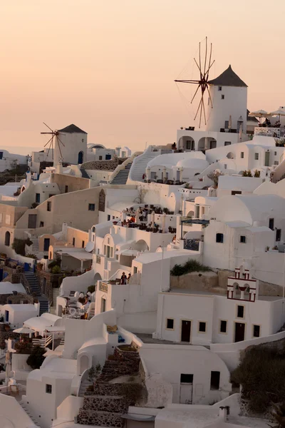 Increíble puesta de sol sobre molinos de viento blancos en la ciudad de Oia y panorama a la isla de Santorini, Thira, Grecia — Foto de Stock