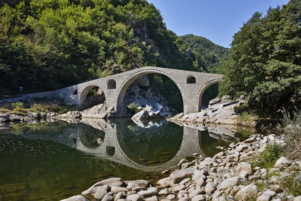 Reflexão da ponte do diabo e da montanha de Rhodopes no rio de Arda, região de Kardzhali — Fotografia de Stock