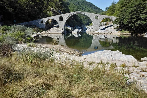 Reflexão da ponte do diabo e da montanha de Rhodopes no rio de Arda, região de Kardzhali — Fotografia de Stock