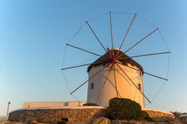 Beyaz üzerinde güneşin son ışınları yel değirmenleri Mikonos Adası üzerinde Cyclades