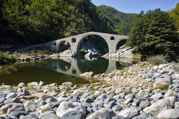 Reflexão da Ponte do Diabo e da montanha Rhodopes no rio Arda, região de Kardzhali — Fotografia de Stock