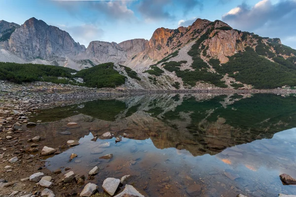 Sunrise with Colored in red rock of Sinanitsa peak and  the lake, Pirin Mountain