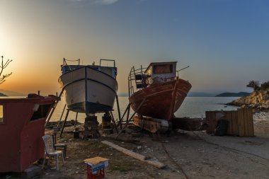 Sunset view of old boats in Thassos town, East Macedonia and Thrace clipart