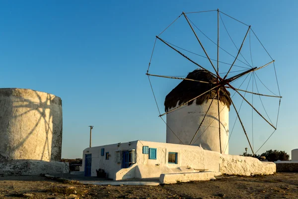 ホワイト上の太陽の最後の線のキクラデス諸島ミコノス島の風車します。 — ストック写真