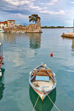 Small boat at Fortification at the port of Nafpaktos town clipart