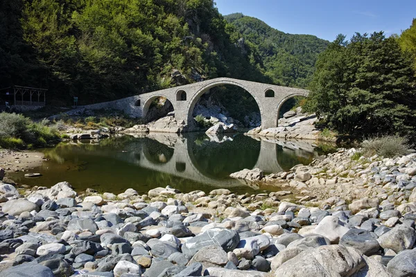 Reflexão da ponte do diabo e da montanha de Rhodopes no rio de Arda, região de Kardzhali — Fotografia de Stock