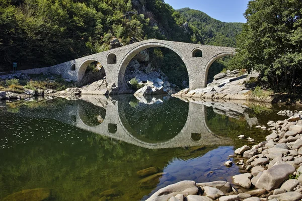 Increíble reflejo del puente del diablo en el río Arda y la montaña Rhodopes — Foto de Stock