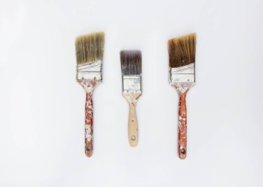 Beyaz arka planda izole edilmiş boyayla kaplanmış üç eski boya.