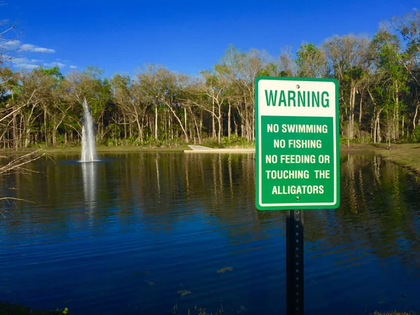 Alligator sinal de aviso na lagoa de retenção — Fotografia de Stock