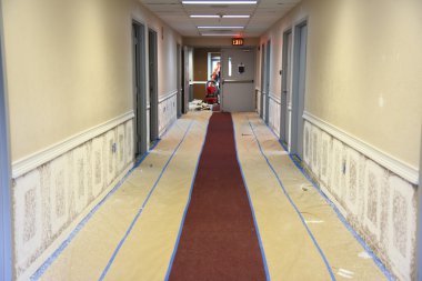 Hallway painting showing paper protection of carpeting clipart