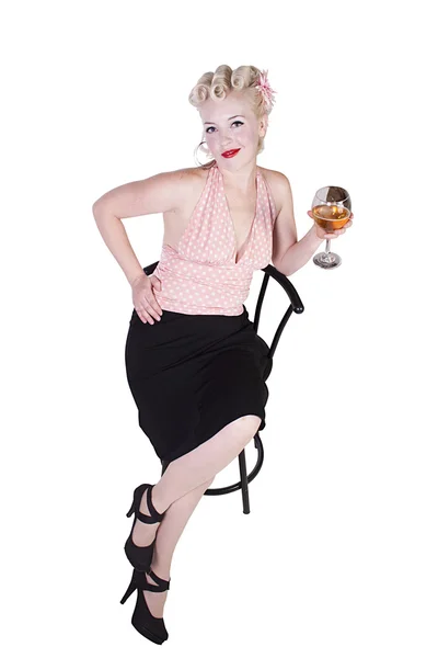 Femeie în rochie de pin-up care bea pe un scaun izolat — Fotografie, imagine de stoc