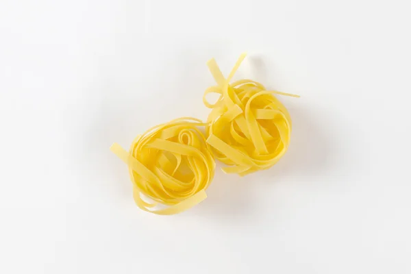Nests of dry pasta tagliatelle — Stock Photo, Image