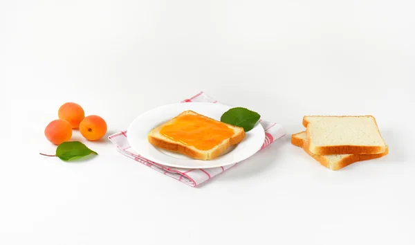 Белый хлеб с абрикосовым джемом — стоковое фото