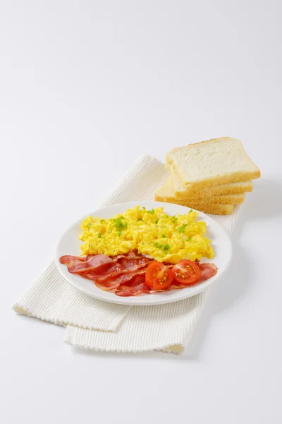 Scrambled eggs and cooked bacon — Stock Photo, Image