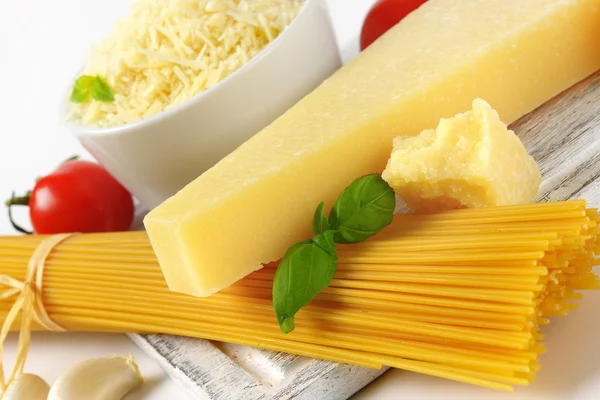 Parmesan cheese and uncooked spaghetti — Stock Photo, Image