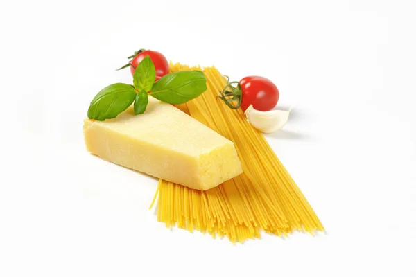 Wedge of parmesan cheese and spaghetti — Stock Photo, Image