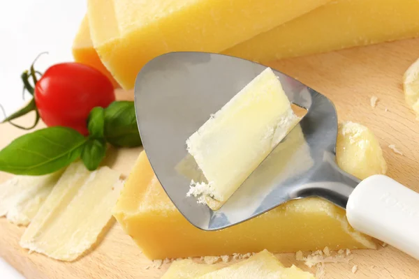 Rebanadora de queso sobre queso parmesano —  Fotos de Stock