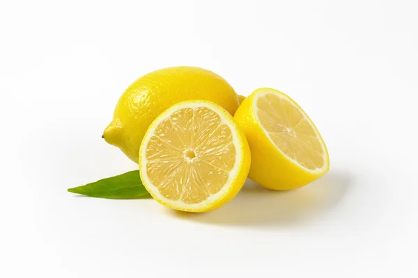 Celé a půlené citrony — Stock fotografie