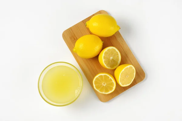 Zumo de limón y limones frescos — Foto de Stock