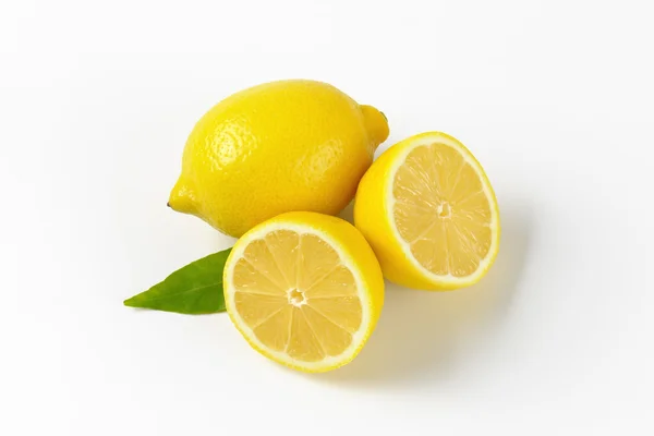 Limões inteiros e cortados pela metade — Fotografia de Stock