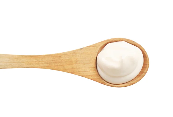 Crema blanca sobre una cuchara de madera —  Fotos de Stock
