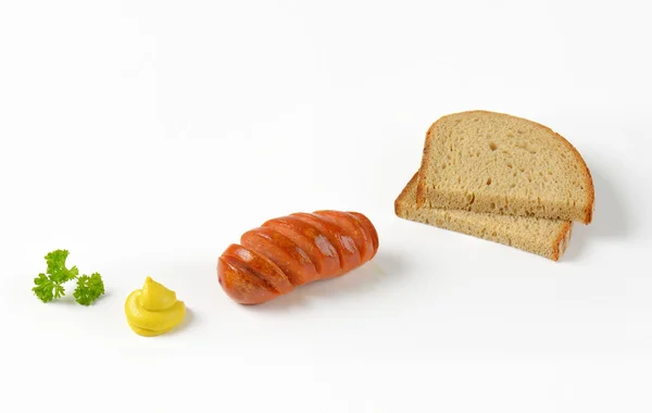 Salsicha torrada, mostarda e pão — Fotografia de Stock