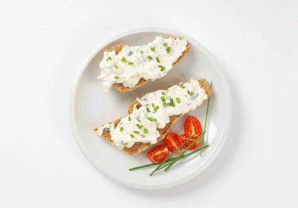 Bread roll with cheese spread — Stock Photo, Image