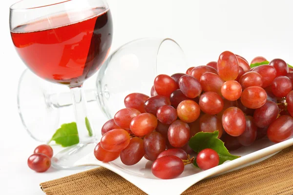 Свежий красный виноград и бокал вина — стоковое фото