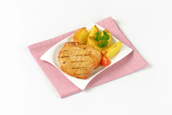 Gegrillte Schweinekoteletts mit Kartoffelkeilen — Stockfoto