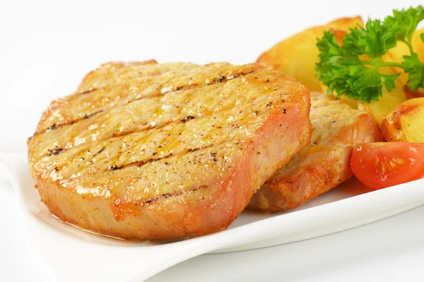 Gegrillte Schweinekoteletts mit Kartoffelkeilen — Stockfoto