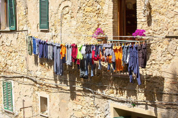 Сушка белья на линиях одежды на улице Вольтерра
