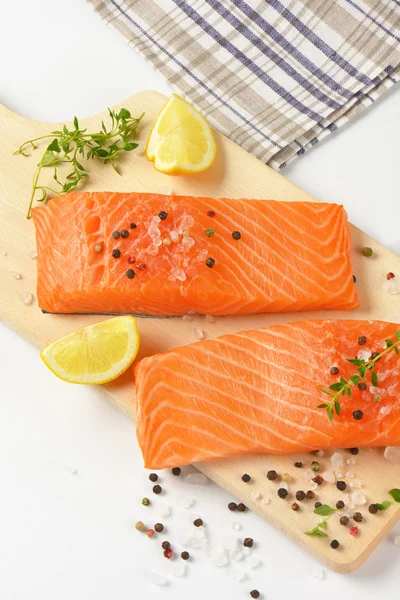 Filetes de salmón crudo en tabla de cortar — Foto de Stock