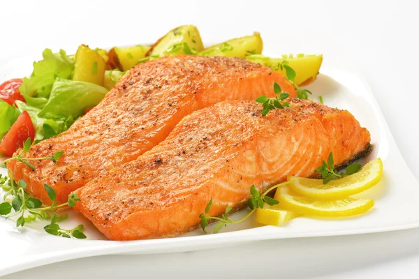 Dish of salmon fillets with roasted potatoes — Stock Photo, Image