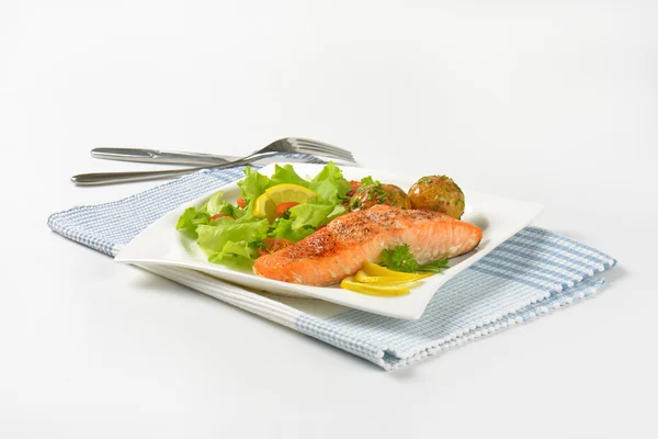 Филе лосося с жареной картошкой и свежими овощами — стоковое фото