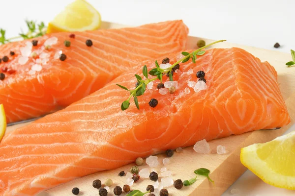 Filetes de salmón crudo en tabla de cortar — Foto de Stock