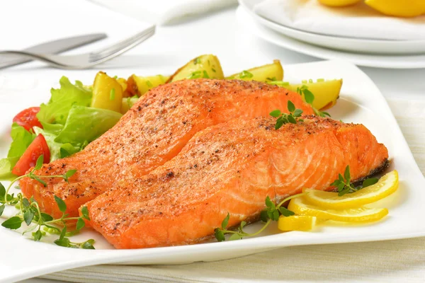 Dish of salmon fillets with roasted potatoes Stock Image