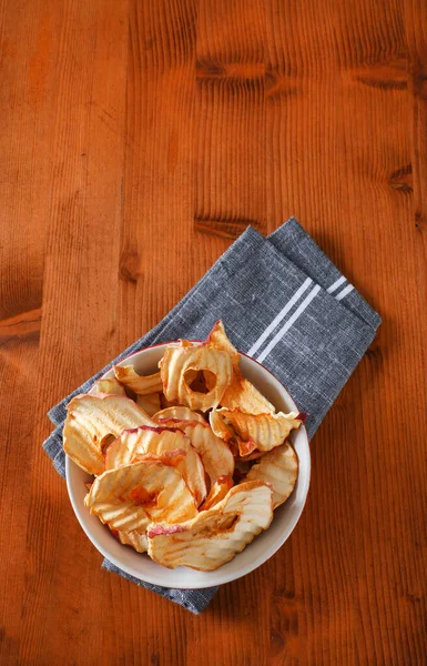 用灰色餐巾纸盛一碗干苹果片 苹果片或苹果环 — 图库照片