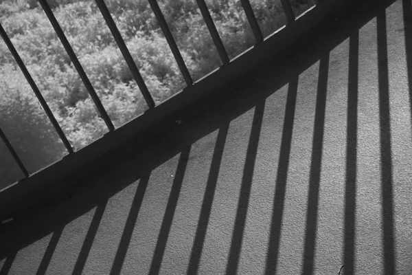 Metal railing throwing shadows on footbridge — Stock Photo, Image