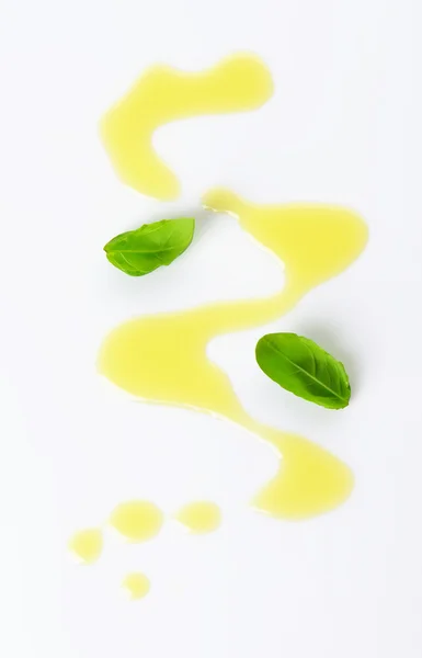 Оливковое масло и листья базилика — стоковое фото